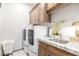 Laundry room with modern appliances and wood cabinets at 2809 W Paso Nuevo Dr, Phoenix, AZ 85086