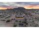 Aerial view of a ranch house at sunset, with stables and distant mountains at 32905 N 140Th St, Scottsdale, AZ 85262