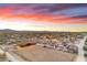 Aerial view of ranch at sunset, featuring barn, arena, and main house at 32905 N 140Th St, Scottsdale, AZ 85262