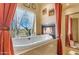 Spa-like bathroom featuring a free-standing tub, fireplace, and tranquil window views at 32905 N 140Th St, Scottsdale, AZ 85262