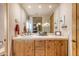 Modern bathroom with wood cabinets and a large mirror at 32905 N 140Th St, Scottsdale, AZ 85262