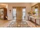 Elegant entryway with a wooden door, ornate rug, and a large mirror at 32905 N 140Th St, Scottsdale, AZ 85262