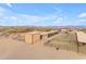 Aerial view of stables with covered areas and a main house in the background at 32905 N 140Th St, Scottsdale, AZ 85262