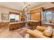 Spacious home office featuring a large desk, built-in cabinets, and a comfortable armchair at 32905 N 140Th St, Scottsdale, AZ 85262