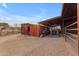 Two rusty storage containers and a tractor under a covered shelter at 32905 N 140Th St, Scottsdale, AZ 85262