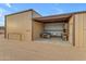 Tan metal building with a covered area for a golf cart and workshop area at 32905 N 140Th St, Scottsdale, AZ 85262