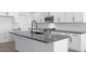 Kitchen island with a dark countertop, white cabinets and stainless steel appliances at 4120 E Ghost Flower Ln, San Tan Valley, AZ 85140
