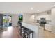 Open kitchen featuring breakfast bar with stools overlooking living area and backyard access at 433 N Neuman Pl, Chandler, AZ 85225