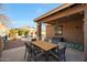 Outdoor patio space with a table, chairs, and view of a pool surrounded by greenery at 433 N Neuman Pl, Chandler, AZ 85225