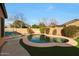 Backyard pool featuring a stone patio, artificial grass, and lounge chairs, perfect for outdoor relaxation and entertainment at 433 N Neuman Pl, Chandler, AZ 85225