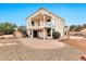 Expansive backyard showcasing a two-story home with a brick patio, fire pit, and desert landscaping at 5010 E Mesquite Wood Ct, Phoenix, AZ 85044