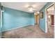 Bright blue carpeted bedroom with a ceiling fan, a painting on the wall, and a bright window at 5010 E Mesquite Wood Ct, Phoenix, AZ 85044