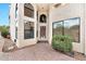 Home featuring a stucco exterior, arched windows, decorative front door, and a brick paver walkway at 5010 E Mesquite Wood Ct, Phoenix, AZ 85044