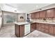 Kitchen with granite countertops, wood cabinets, island, stainless steel dishwasher and tile backsplash at 5010 E Mesquite Wood Ct, Phoenix, AZ 85044