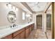 Large main bathroom with double sinks, wooden cabinets, tiled floor, glass shower, and plentiful counterspace at 5010 E Mesquite Wood Ct, Phoenix, AZ 85044