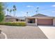 Beautiful mid-century modern home with a large driveway and mature landscaping at 5201 E Winchcomb Dr, Scottsdale, AZ 85254