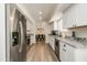 Modern kitchen with white cabinets, granite countertops, and stainless steel appliances at 6073 W Caribe Ln, Glendale, AZ 85306