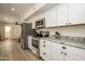 Modern kitchen with white cabinets, granite countertops, and stainless steel appliances at 6073 W Caribe Ln, Glendale, AZ 85306