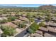 Aerial view of a luxury community nestled against mountains, featuring homes with tile roofs and a golf course at 6970 E Hibiscus Way, Scottsdale, AZ 85266