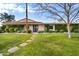 Single-story home with Spanish-style tile roof, landscaped lawn, and walkway at 7420 N San Manuel Rd, Scottsdale, AZ 85258