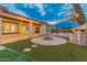 Outdoor oasis with fire pit, turf, and basketball court at 7556 W Crystal Rd, Glendale, AZ 85308