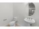 Bathroom with toilet, sink, and oval mirror at 7556 W Crystal Rd, Glendale, AZ 85308