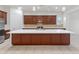 Large kitchen island with white countertop and brown cabinets at 7556 W Crystal Rd, Glendale, AZ 85308