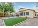 Lovely backyard with artificial grass, covered patio, a barbecue grill, and privacy fencing at 8219 W Globe Ave, Phoenix, AZ 85043