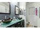 Modern bathroom featuring dual vessel sinks, black framed mirrors, and neutral gray tones at 8219 W Globe Ave, Phoenix, AZ 85043