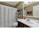 Well-lit bathroom featuring a vanity with a modern faucet and decorative shower curtain at 8219 W Globe Ave, Phoenix, AZ 85043