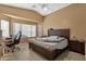 Spacious bedroom featuring a large window with natural light, a ceiling fan, and neutral décor at 8219 W Globe Ave, Phoenix, AZ 85043