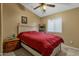 Bedroom featuring a comfortable bed, ceiling fan, nightstand, and a bright window at 8219 W Globe Ave, Phoenix, AZ 85043