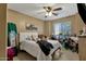 Bedroom featuring a queen bed, ceiling fan, and natural light through a bright window at 8219 W Globe Ave, Phoenix, AZ 85043