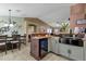 Open-concept kitchen with a breakfast bar, seating, and seamless flow into the dining area at 8219 W Globe Ave, Phoenix, AZ 85043