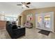 Open living room with tile flooring, ceiling fan, and natural light from the door leading to the outside patio at 8219 W Globe Ave, Phoenix, AZ 85043