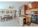 Kitchen with wood cabinets, black appliances, and a breakfast bar at 11029 W Mountain View Dr, Avondale, AZ 85323