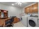 Laundry Room with wood cabinets and built-in desk at 12506 W Castle Rock Dr, Sun City West, AZ 85375