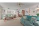 Open living area with teal sofas and a view into dining area at 12506 W Castle Rock Dr, Sun City West, AZ 85375