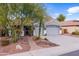 One-story home with gray exterior, three-car garage, and landscaped front yard at 12522 W Llano Dr, Litchfield Park, AZ 85340