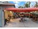 Outdoor kitchen with built-in grill and bar seating under a shade sail at 12522 W Llano Dr, Litchfield Park, AZ 85340