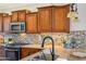 Well-equipped kitchen featuring wood cabinets and tile backsplash at 12911 W Eagle Ridge Ln, Peoria, AZ 85383