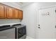 Laundry room with washer, dryer, and wood cabinets at 12911 W Eagle Ridge Ln, Peoria, AZ 85383