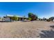 Wide backyard showcases gravel landscaping, mature trees, and the home's rear facade at 13219 W Prospect Dr, Sun City West, AZ 85375