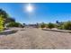 Gravel backyard with young trees and a community pool in the background at 13219 W Prospect Dr, Sun City West, AZ 85375