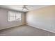 Neutral bedroom with a ceiling fan, carpet, and a window looking out onto the neighborhood at 13219 W Prospect Dr, Sun City West, AZ 85375