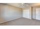 Neutral bedroom with a ceiling fan, closet, carpet, and a door to other rooms of the house at 13219 W Prospect Dr, Sun City West, AZ 85375