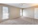 Neutral bedroom with a ceiling fan, carpet, and two windows overlooking the property at 13219 W Prospect Dr, Sun City West, AZ 85375