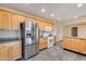 Kitchen with stainless steel fridge, tile floors, and honey-colored cabinetry at 13219 W Prospect Dr, Sun City West, AZ 85375