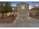 Two-story house with a beige exterior, stone accents, and a two-car garage at 13257 W Watson Ln, Surprise, AZ 85379