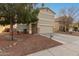 Two-story house with a beige exterior, stone accents, and a two-car garage, tree in front yard at 13257 W Watson Ln, Surprise, AZ 85379